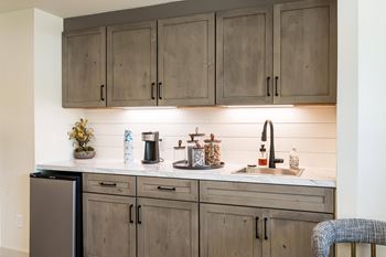 A kitchen with wooden cabinets and a marble countertop.at 3TEN, Springfield, IL
